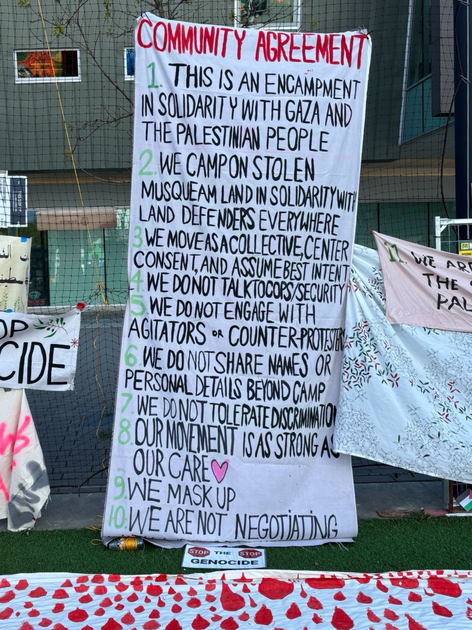 a sign showing a community agreement in solidarity with Gaza and the Palestine people at an encampment