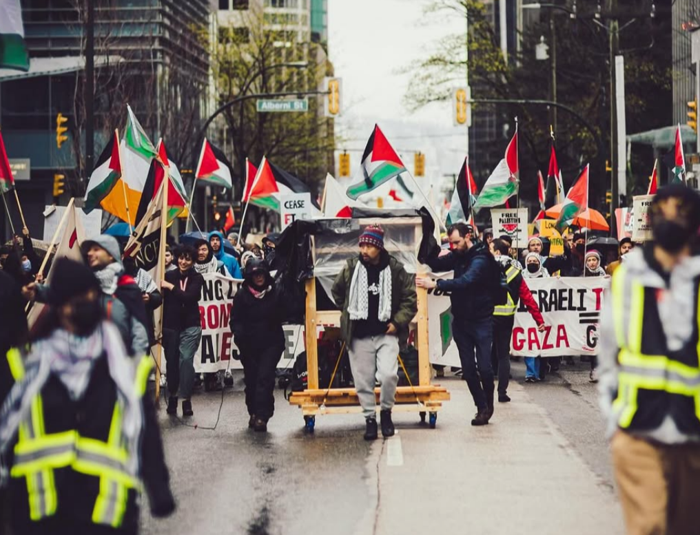 people marching in a protest with Palestinian flags